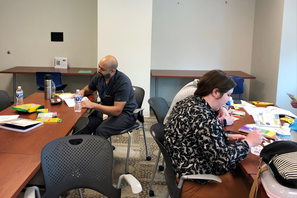 Three residents sitting at a table in a classroom