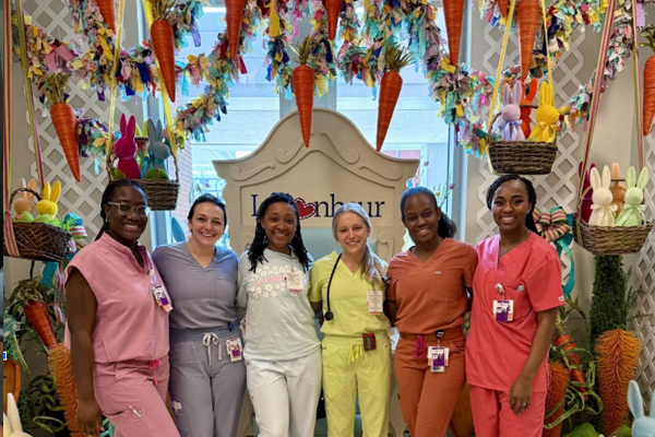 Female residents posing in front of decorations that include carrots