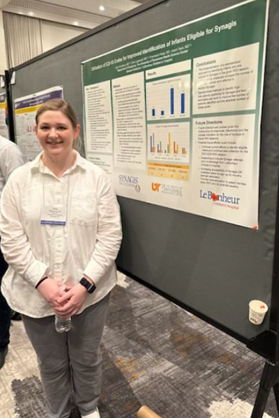 Resident standing before a poster presentation