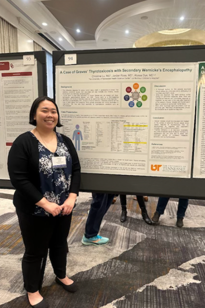 Resident standing before a poster presentation