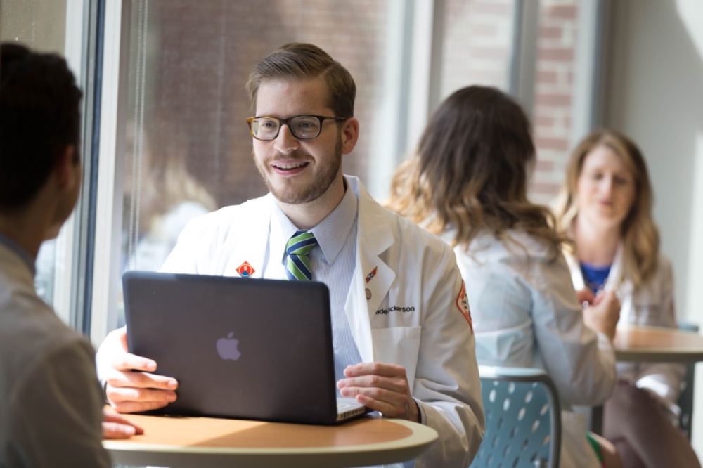 PharmD student at a computer, smiling. 