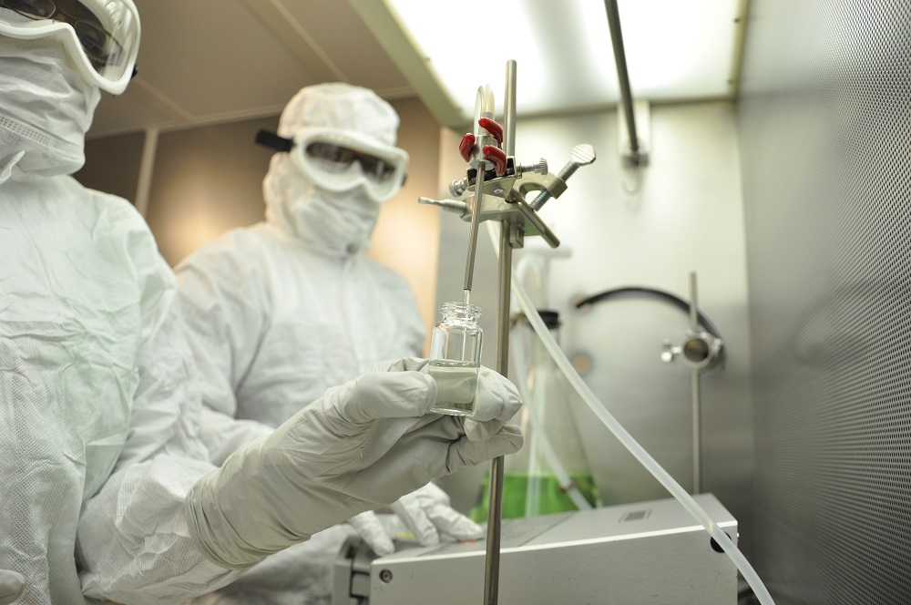 Filling a vial in sterile environment.