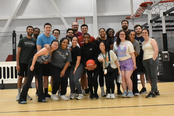 Residents posing together on an indoor basketball court during a recreational activity.