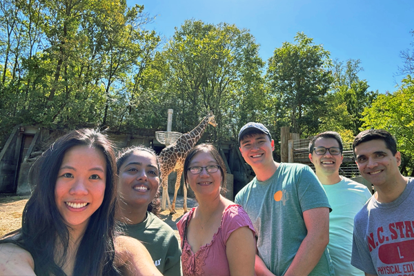 Residents outdoors at the zoo with a giraffe in the background