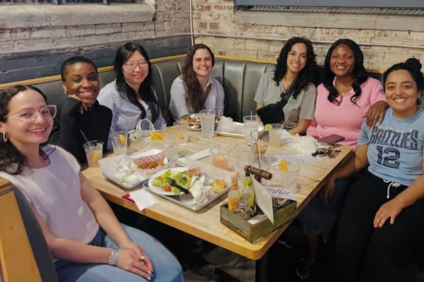 Group seated around a long restaurant table enjoying a meal together