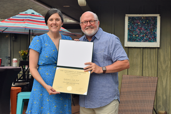 Graduate holding certificate with faculty member