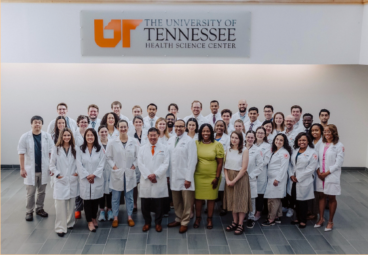 Group photo take by a University of Tennessee Health Science Center logo on a wall