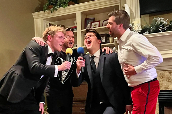 Male residents singing karaoke at a holiday party